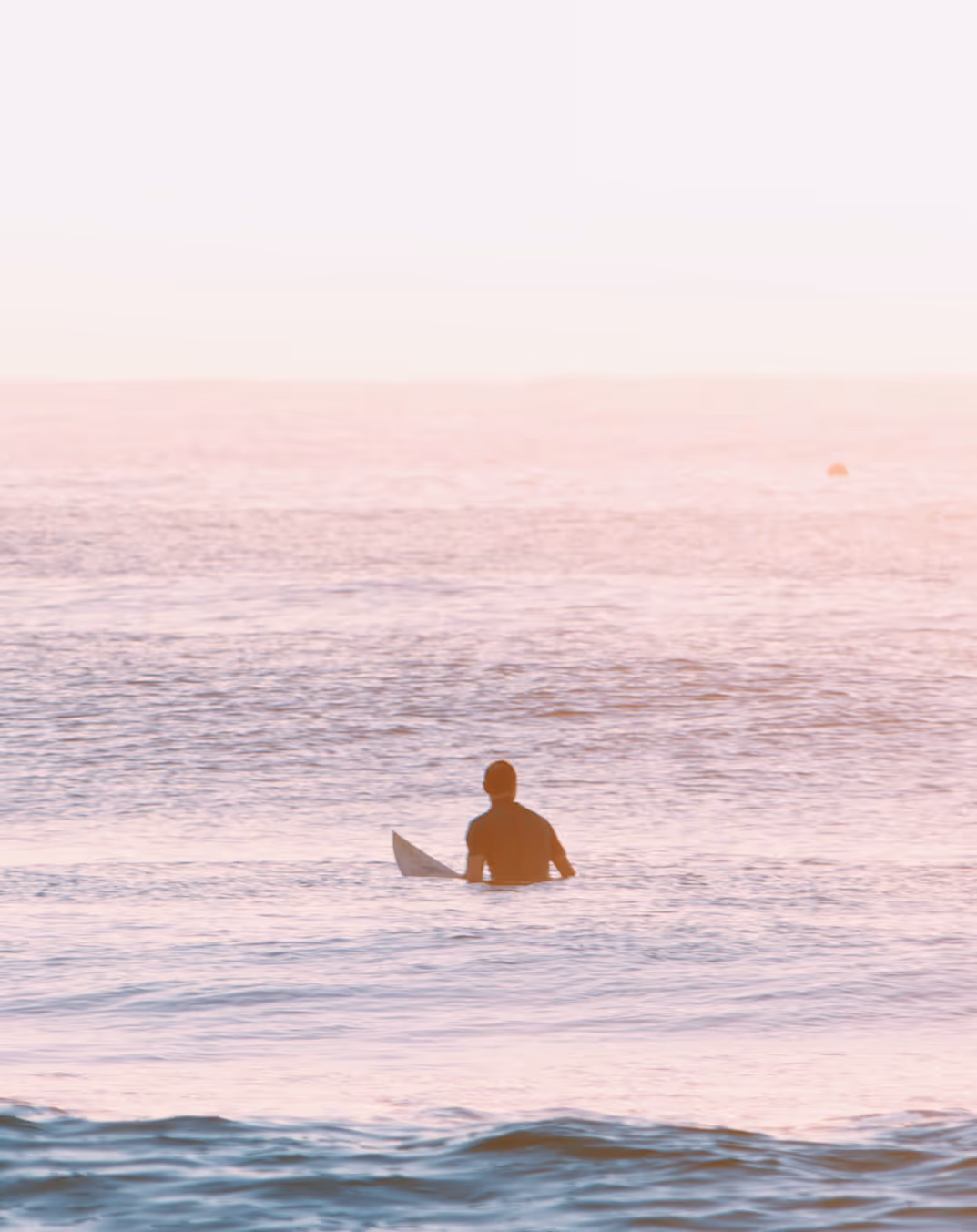 surfer is sitting in the water in the morning