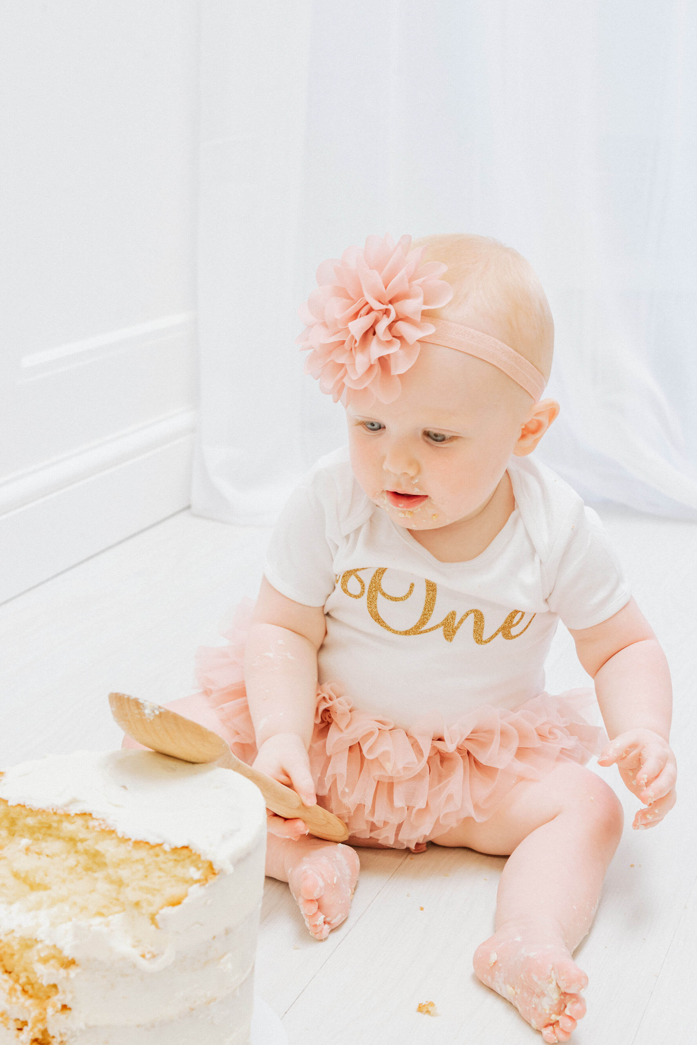 Baby Delilah looking at her birthday cake, shot by Gemma Randall ©