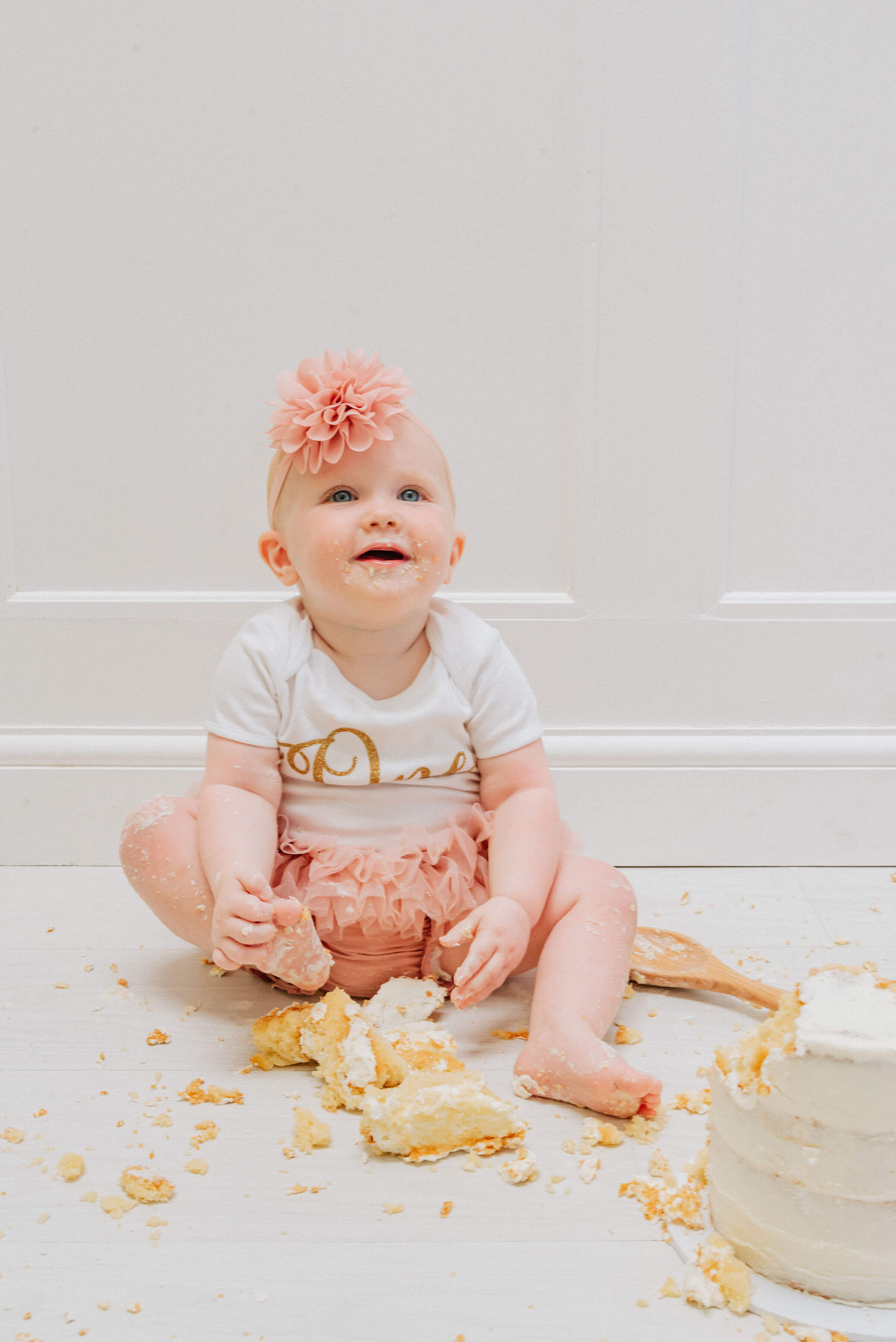 Baby Delilah sitting with cake all around her, shot by Gemma Randall ©