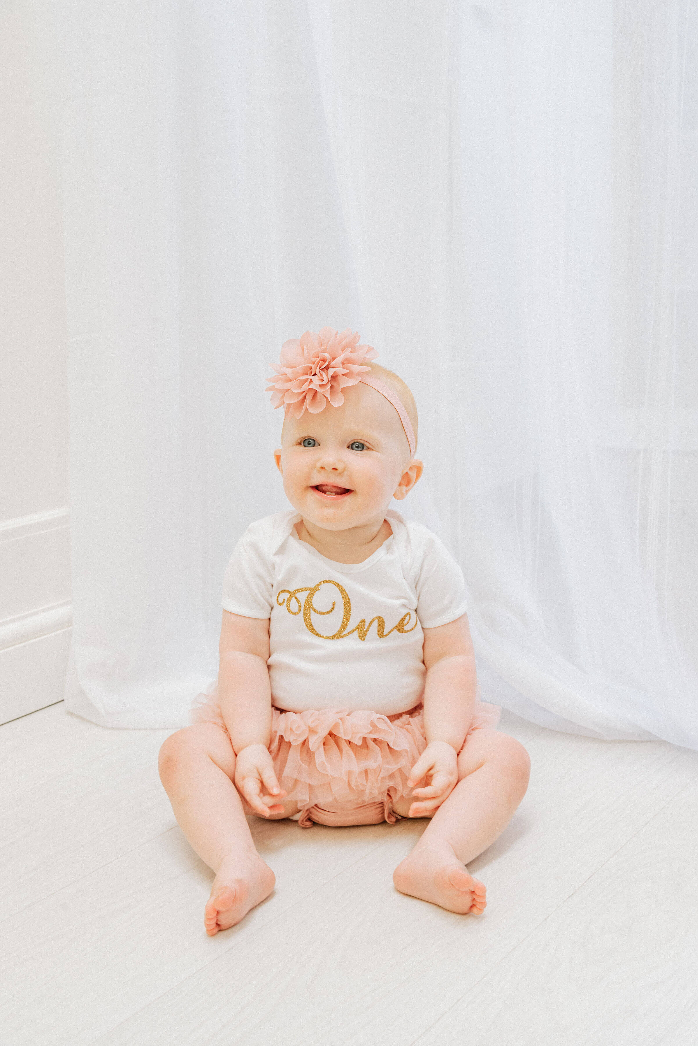 Baby Delilah grinning into the camera, shot by Gemma Randall ©