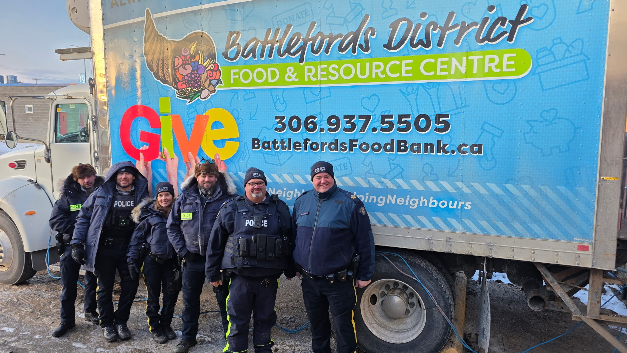 RCMP members standing beside a patrol car filled with donated food items during the ESF “Pack a Patrol Car” food drive, which raised over $20,000 in food and monetary donations.