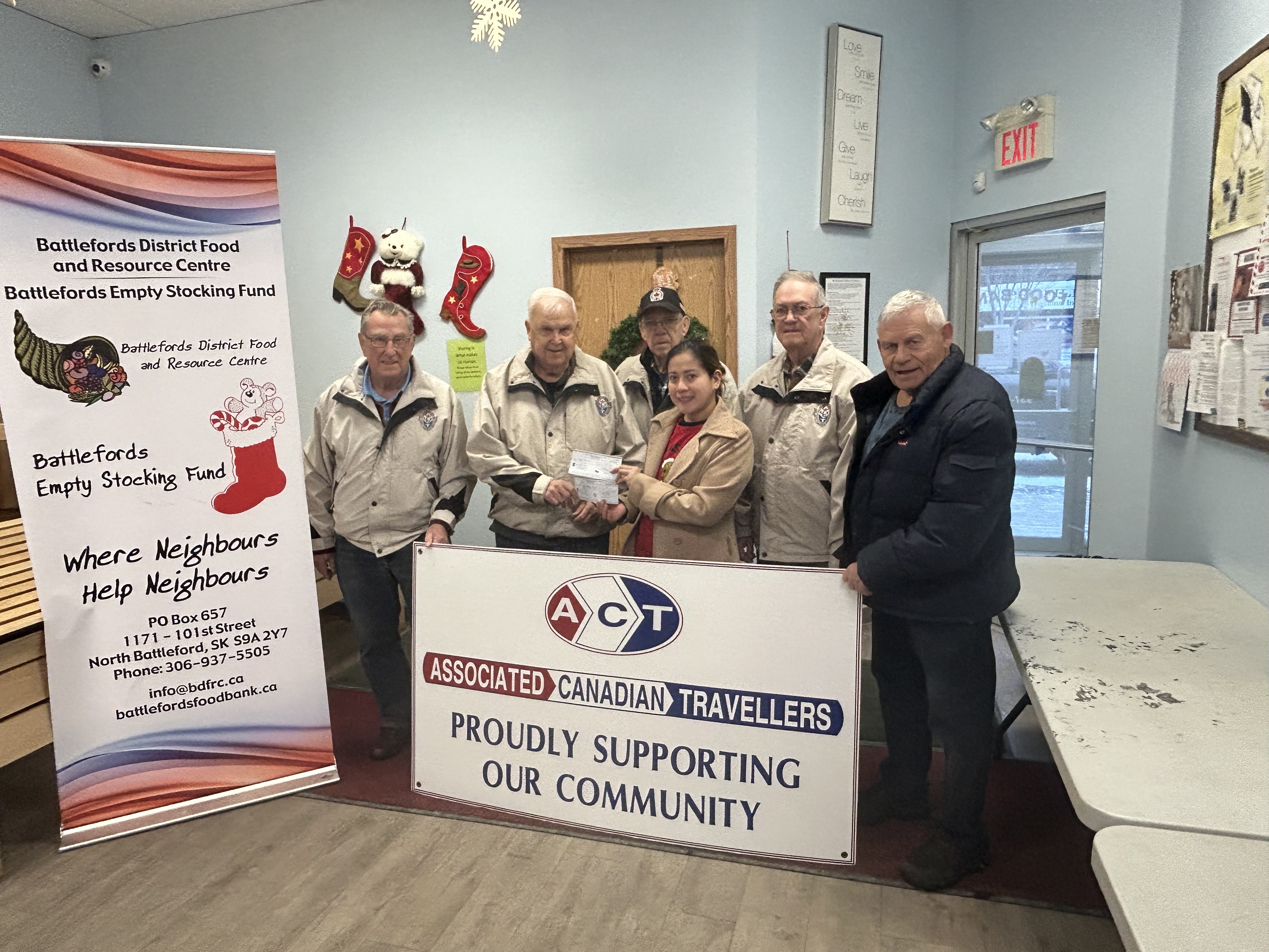 Members of the Associated Canadian Travellers Club presenting a cheque donation to support the Empty Stocking Fund and the food bank.