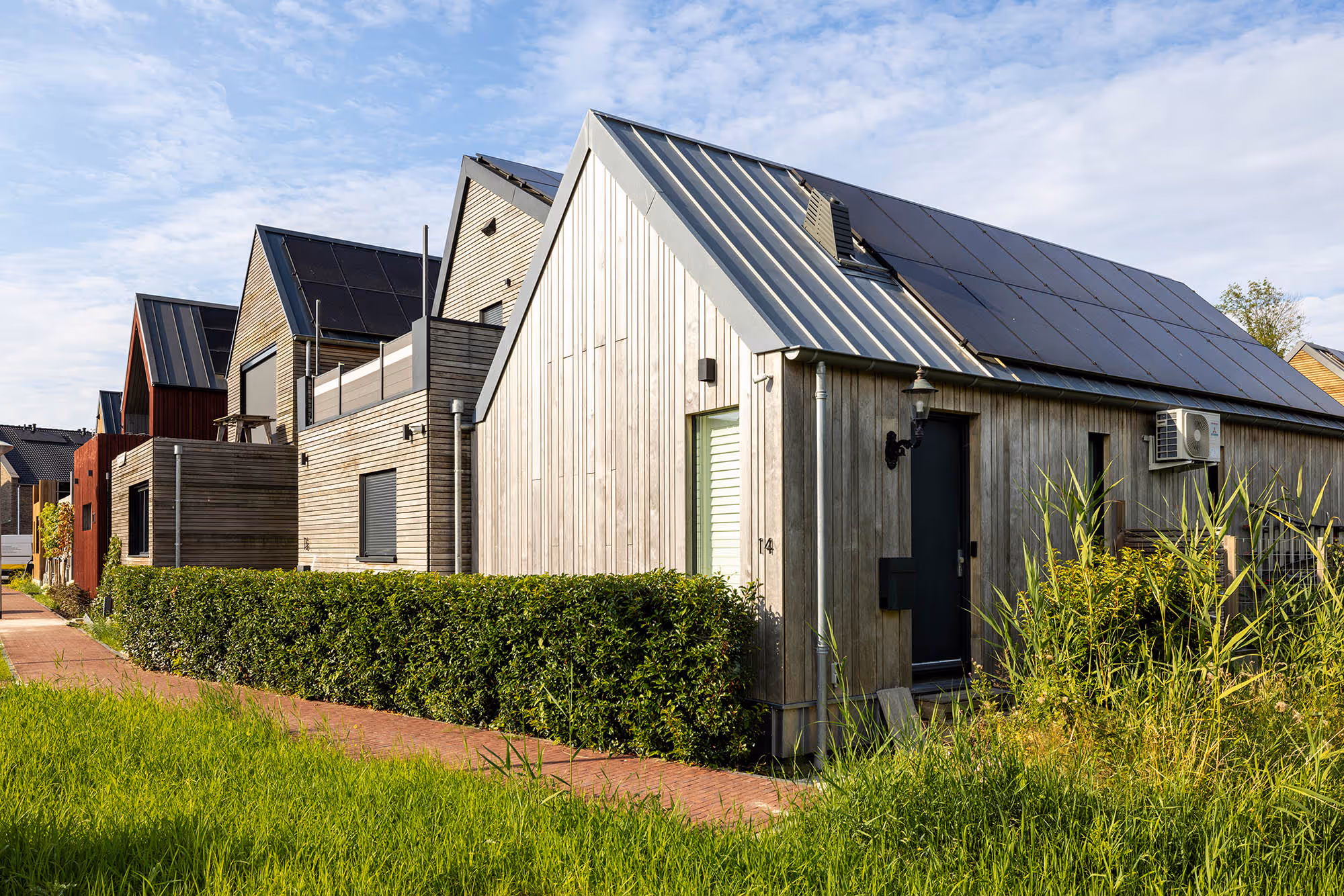 3 WikiHouses side by side surrounded by a garden