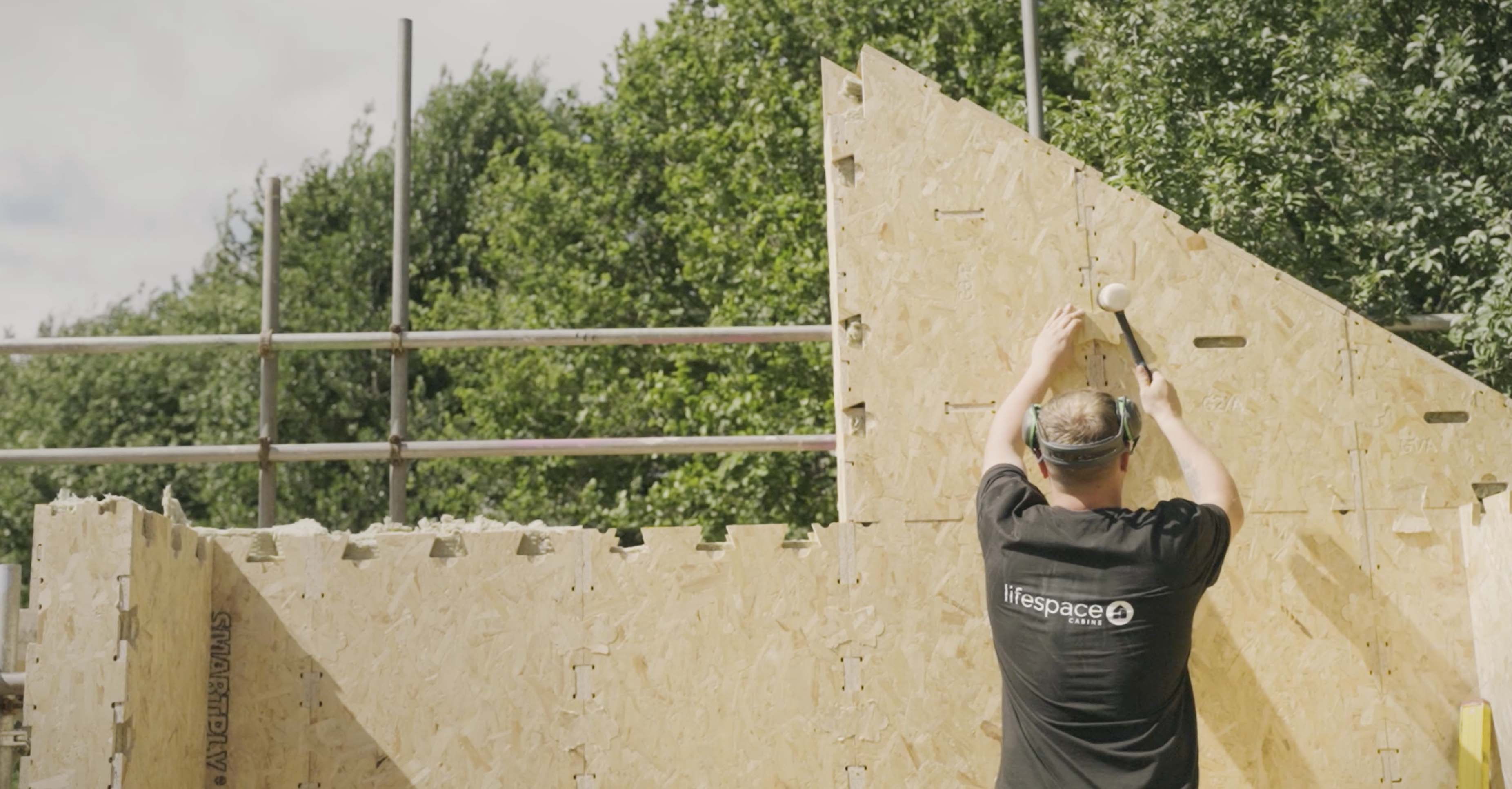 Builder assembles WikiHouse wall.