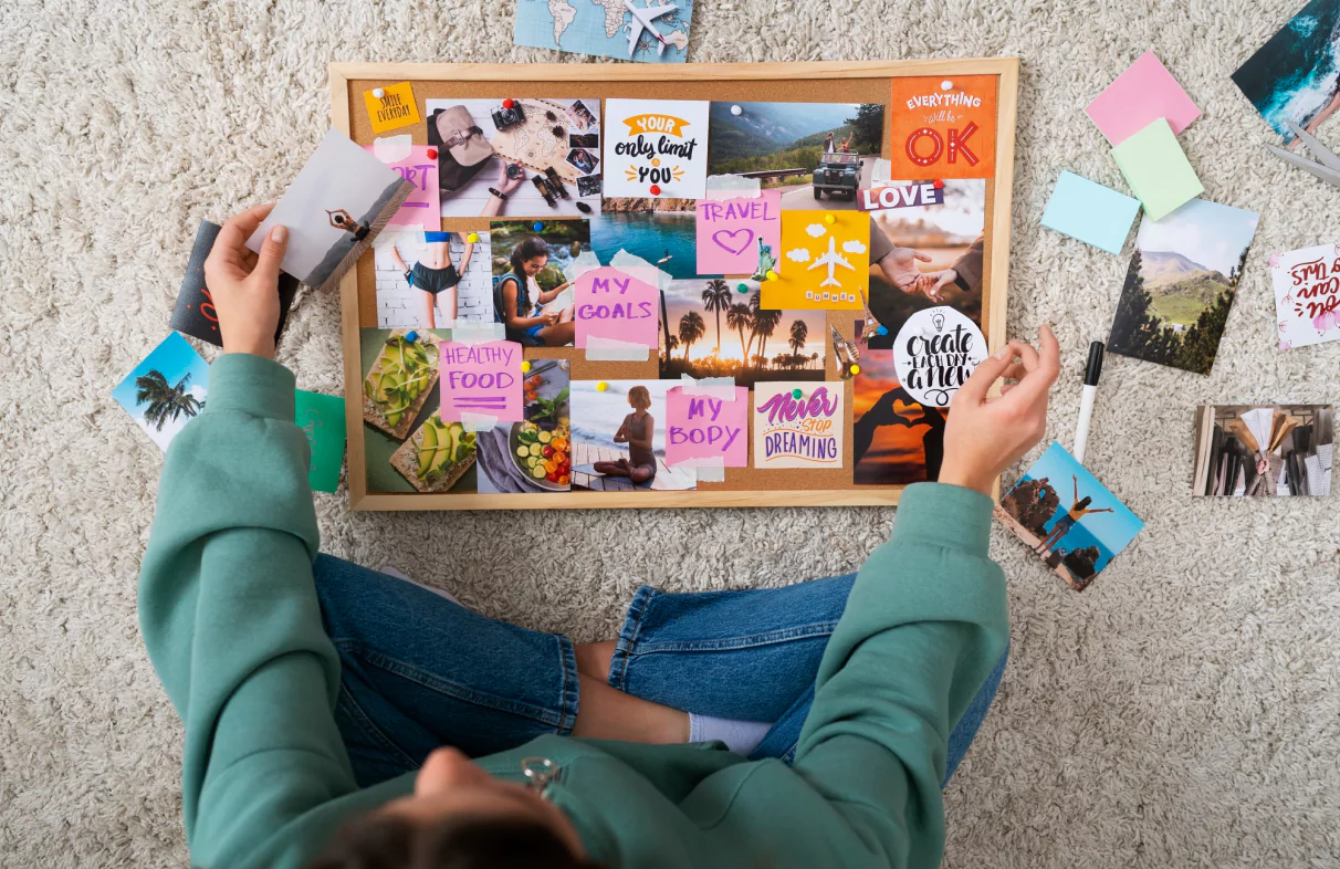 A woman examining a board filled with an assortment of photos and postcards