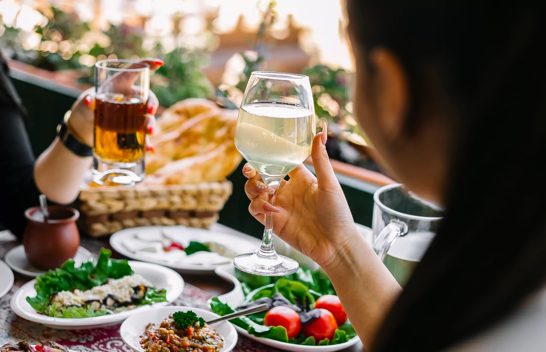 People clinking wine glasses in a celebratory toast at a table