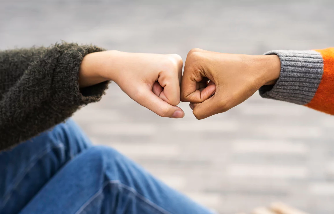 Two people making a fist in a gesture of determination
