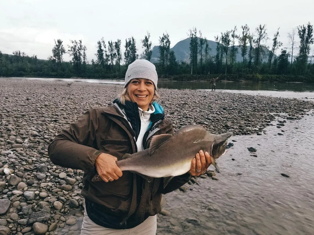 A Fraser River Lodge fishing guest showing off her catch of a pink salmon, also known as a humpie!
