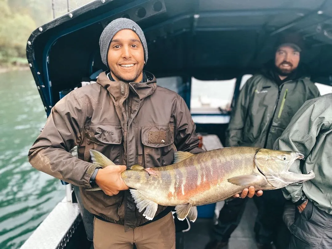 Fisherman with a fish on the river boat
