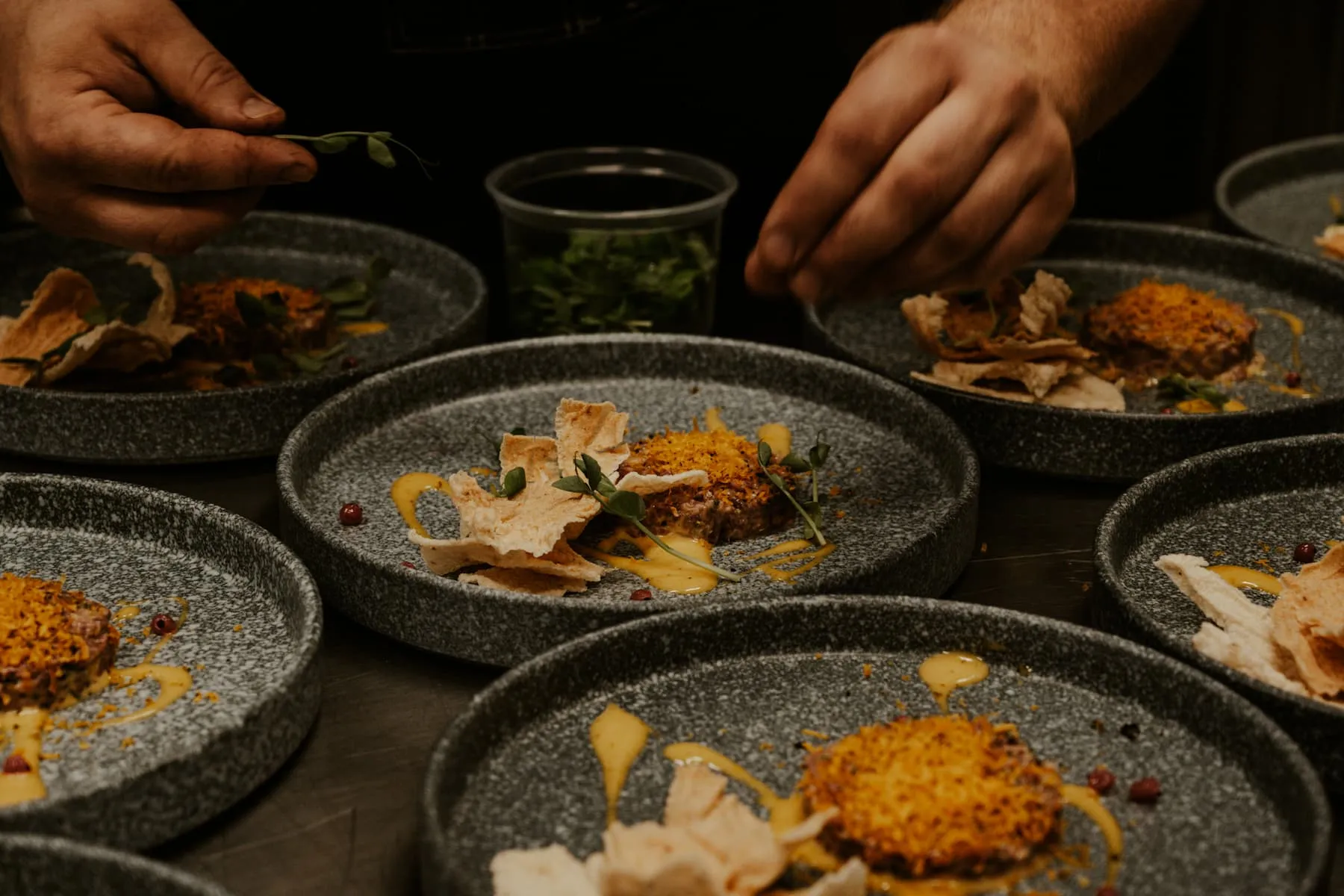 Hand sprinkles spice on an expertly prepared dish