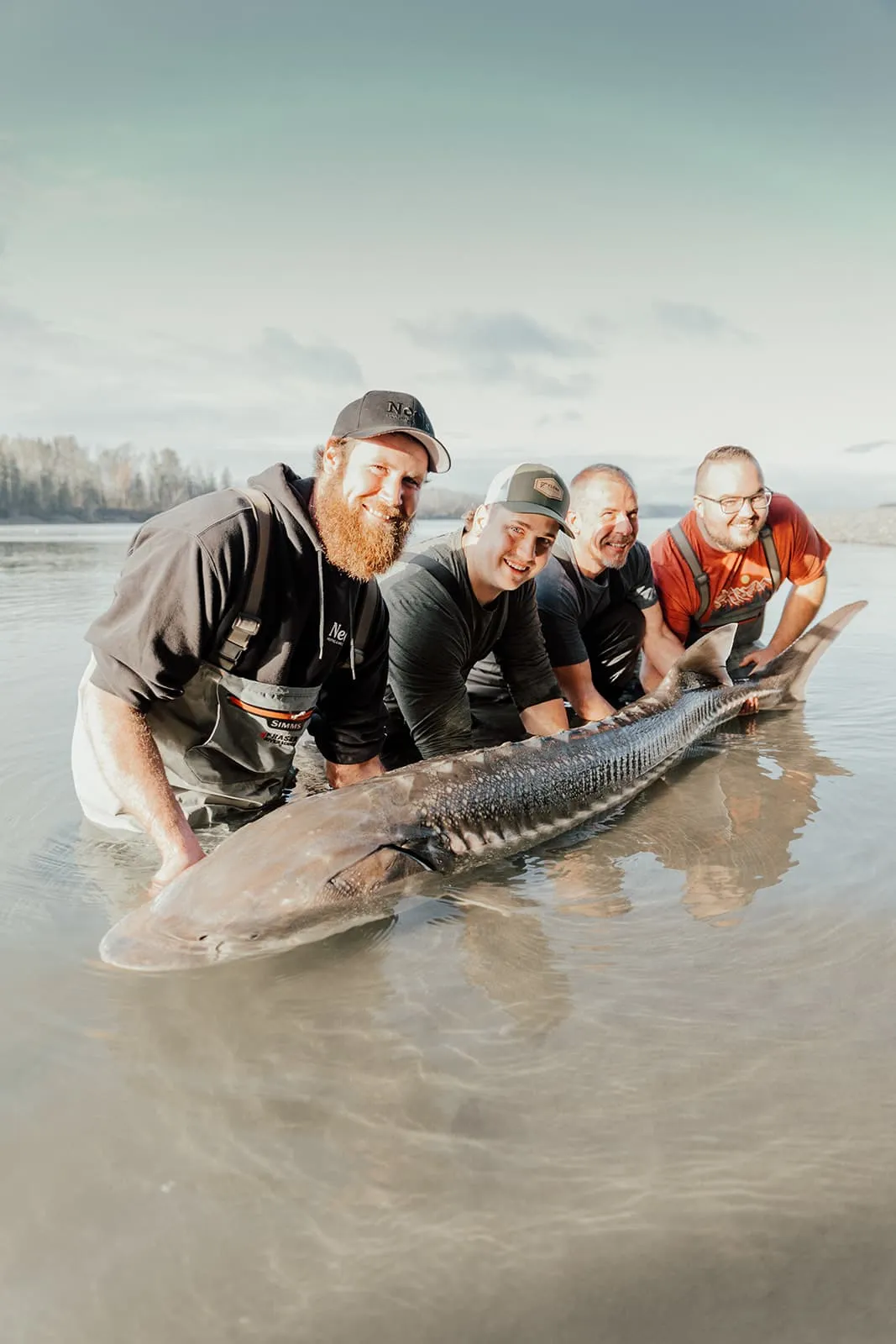 A group of girls holding a sturgeon in the river