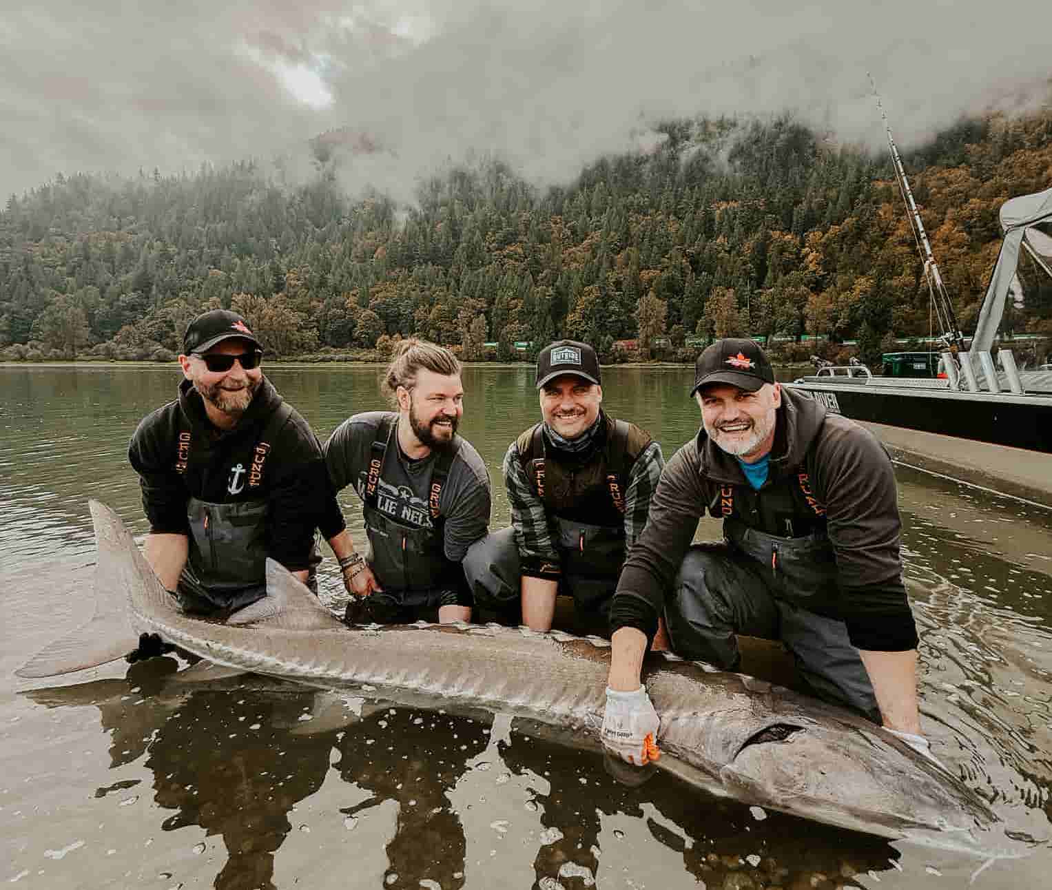A group of girls holding a sturgeon in the river
