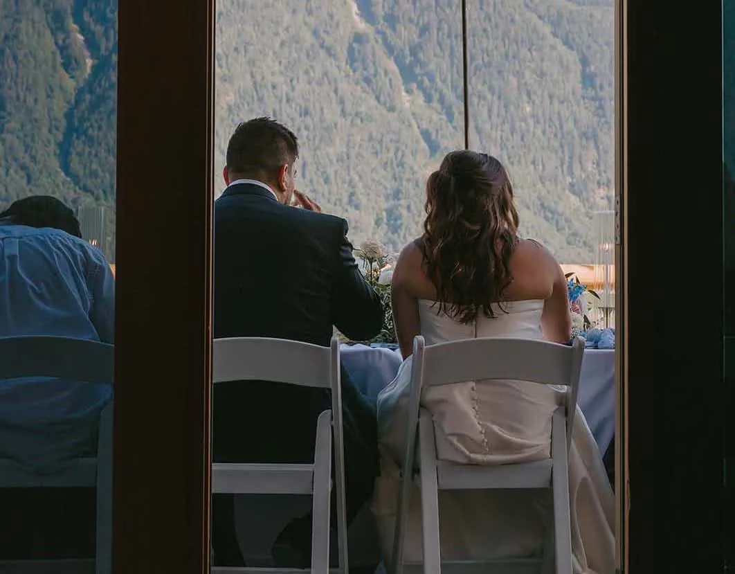 a newly wedded couple enjoying dinner with mountain views at the Fraser River Lodge