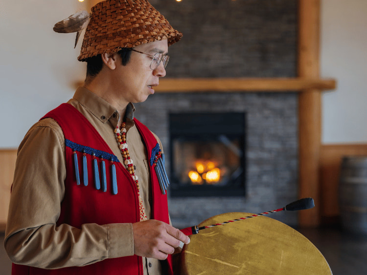 An Indigenous man drumming