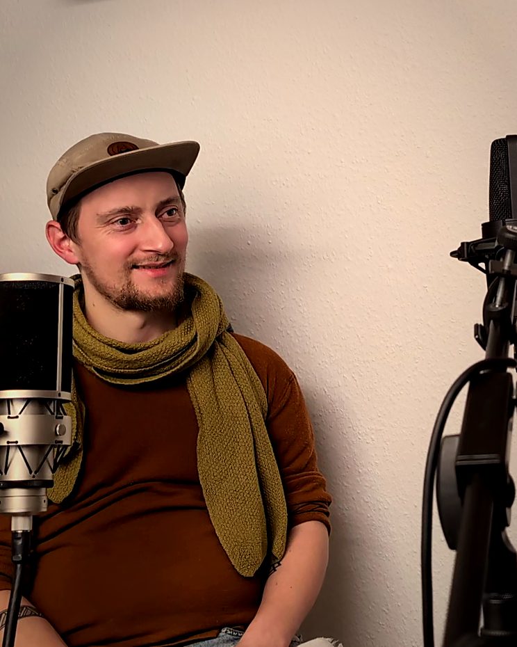 Gitarrist Nikolai Voigt lächelt während des Podcast-Gesprächs