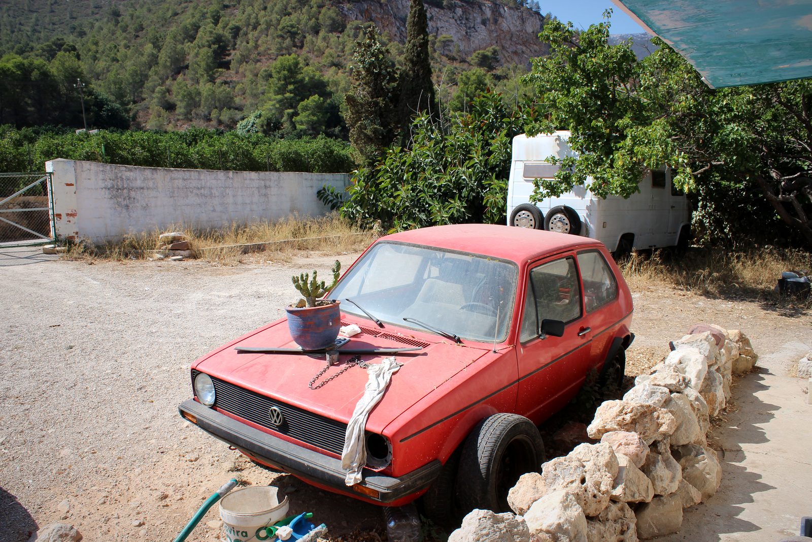 Roter VW Golf mit Kaktus auf der Motorhaube vor spanischer Berglandschaft