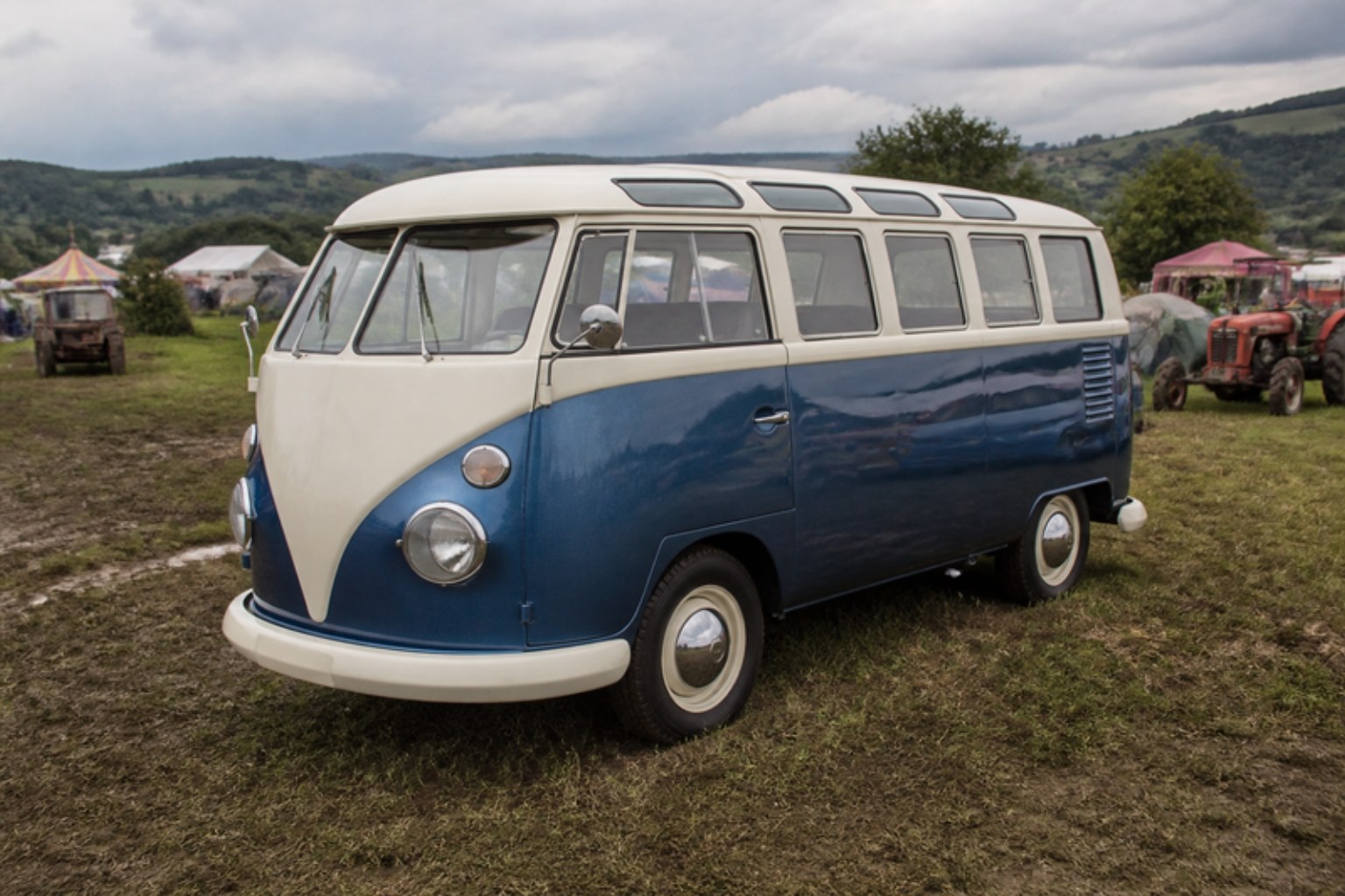 Restaurierter VW T1 in Blau und Cremeweiß auf einer Festivalwiese, KI-generiertes Bild