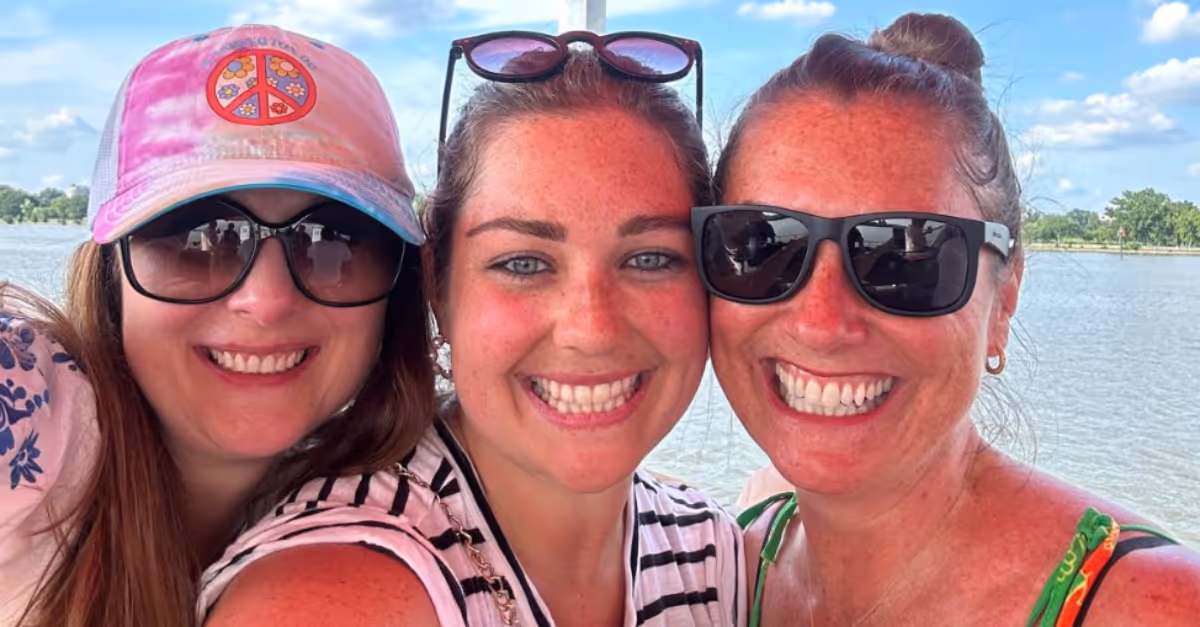 Three female CoreView staff taking a selfing in front of a lake