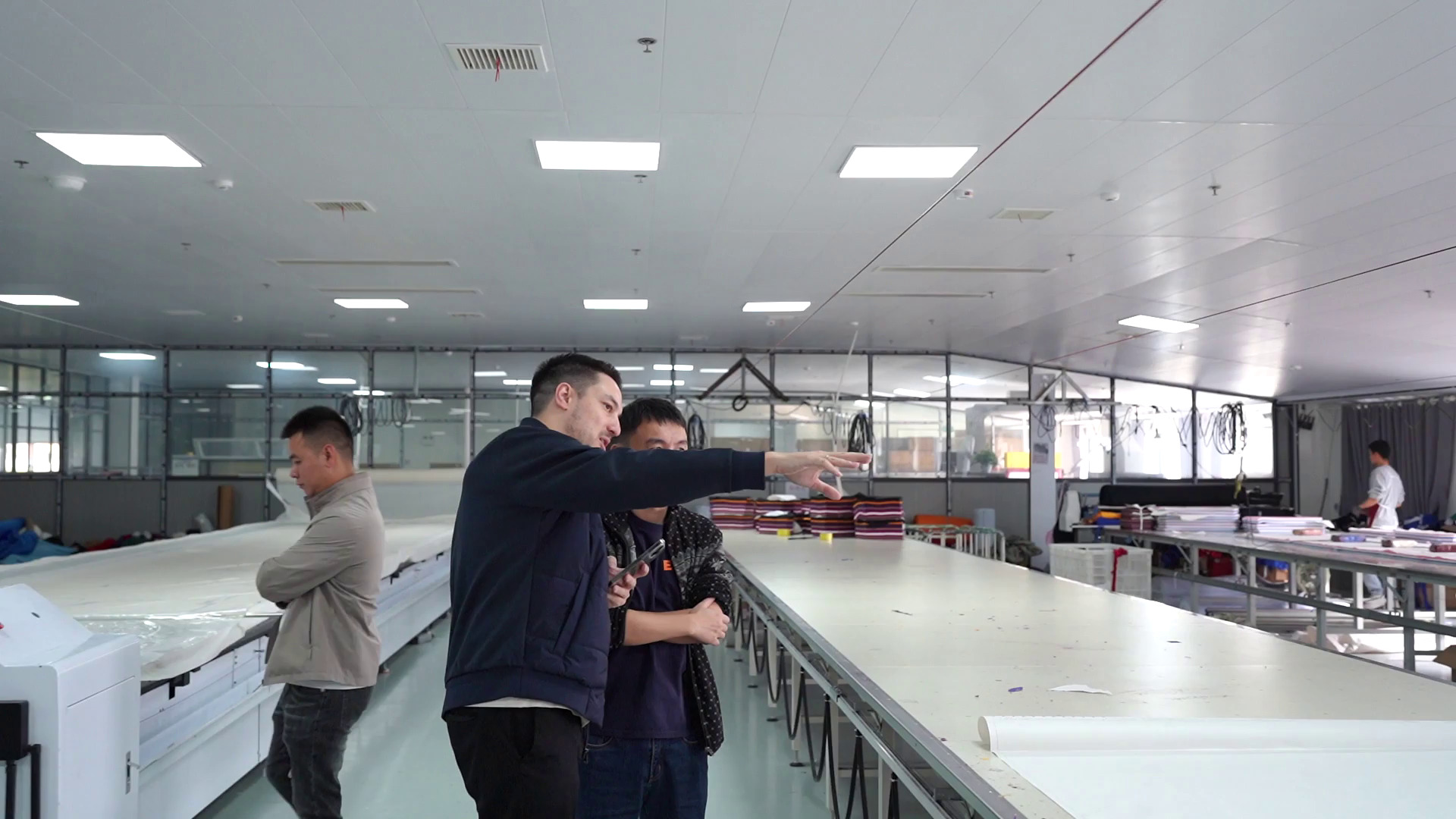 Our sourcing team walking a garment factory production floor with a buyer during an on-site factory visit