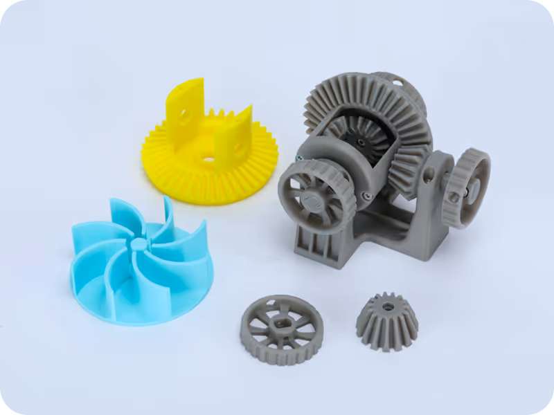 3D printed prototype parts and gears laid out on a bench