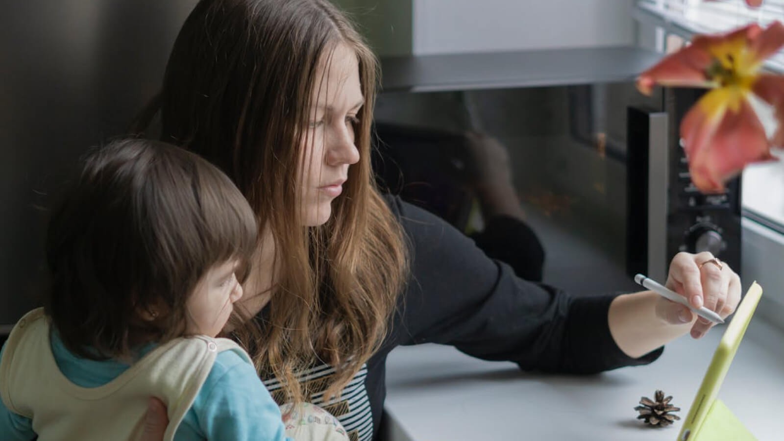 key stage 1 child looking at an ipad with her mum reading a story