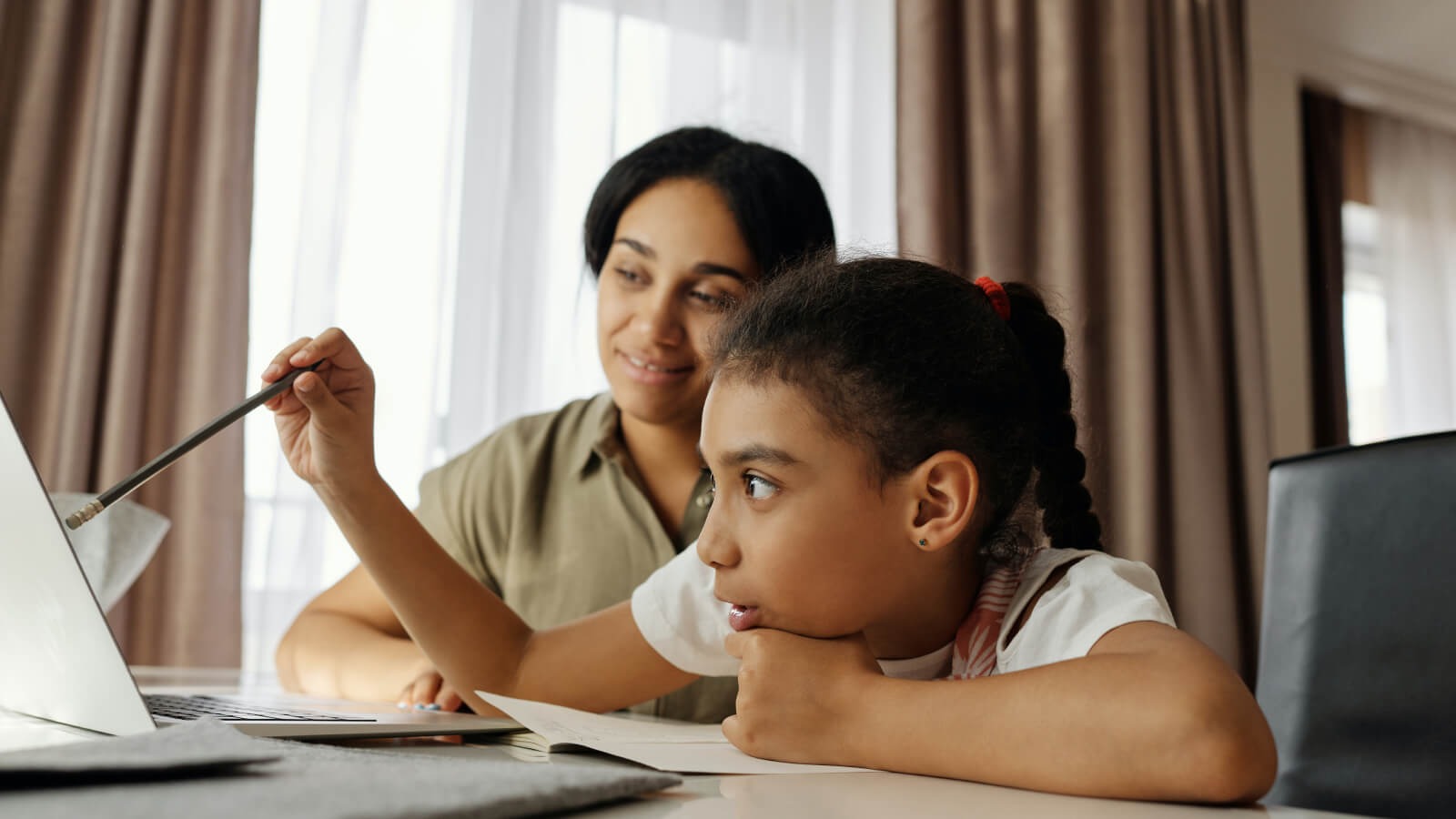 key stage 2 child working at a laptop with mum