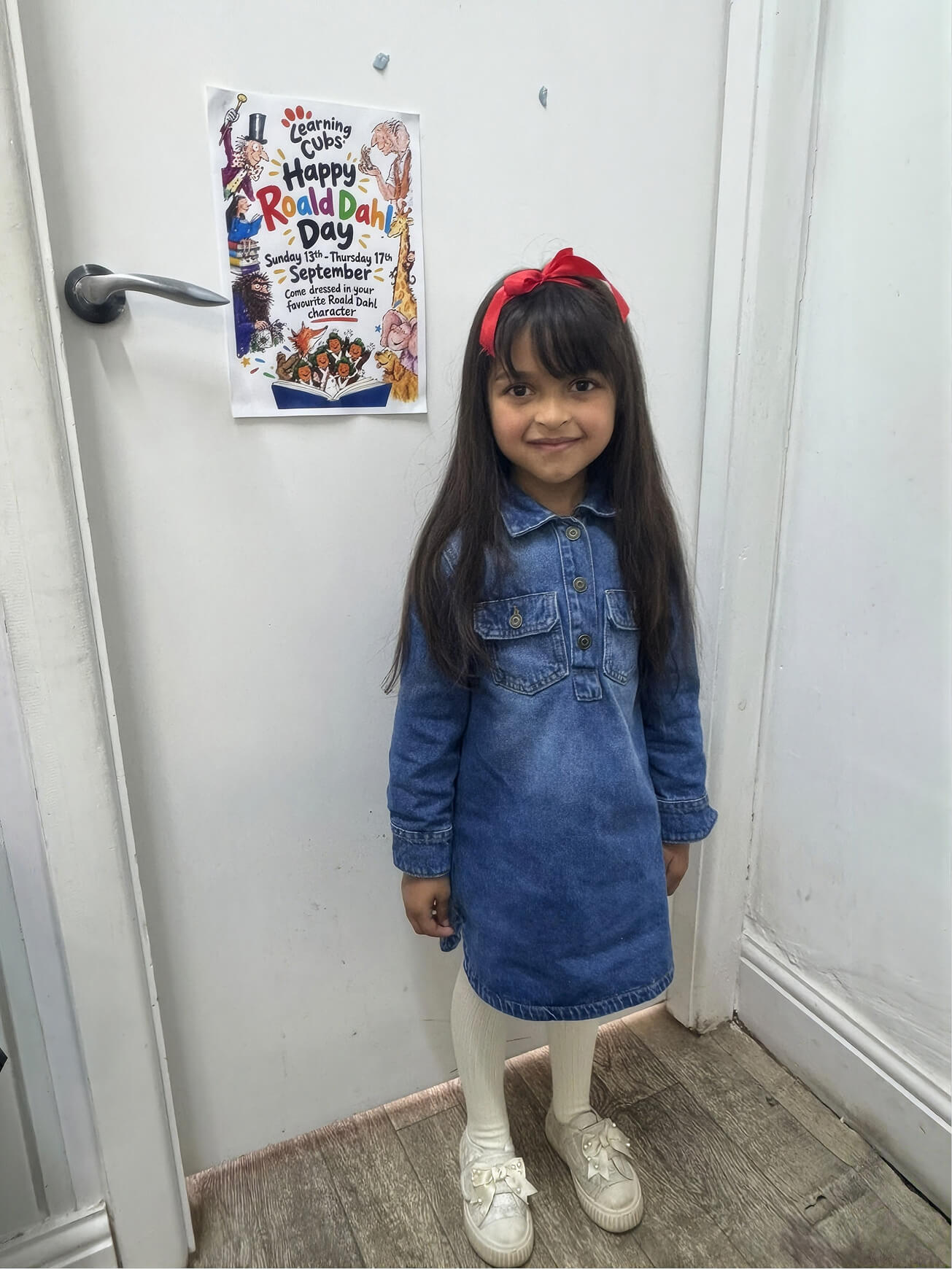 Inayah dressed as Matilda with a red bow