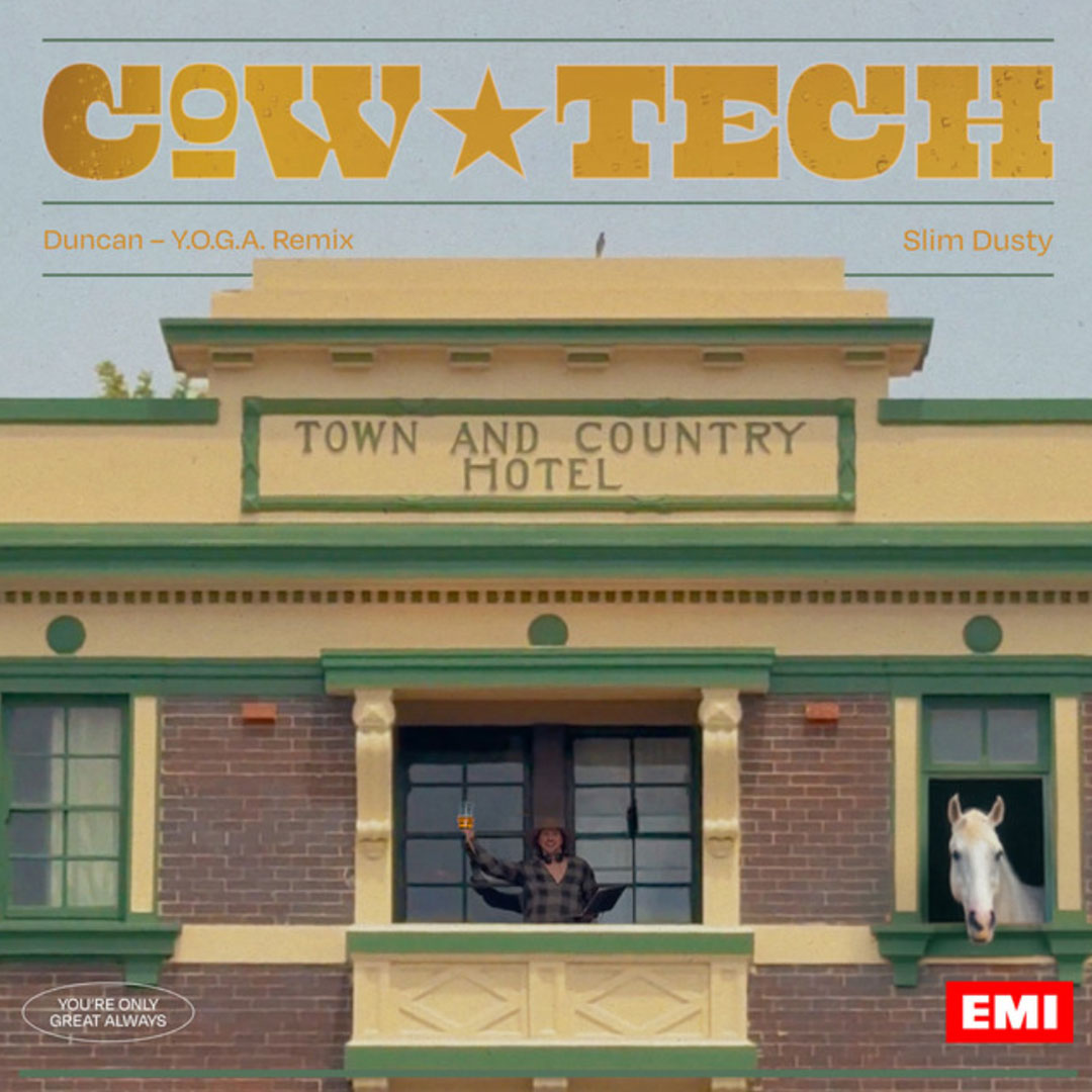 Front view of Town and Country Hotel building with a person holding a drink on the balcony and a white horse looking out from a window.