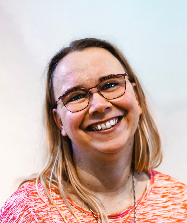 Smiling couple posing in front of a rocky waterfall outdoors.