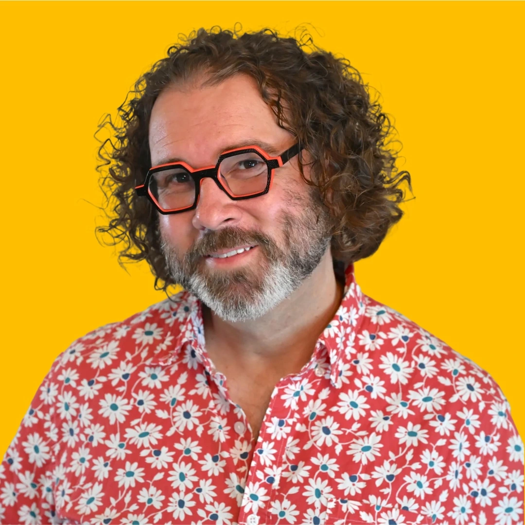 Nick's headshot against a yellow background