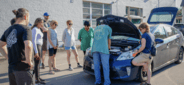 Group standing around car with hood open
