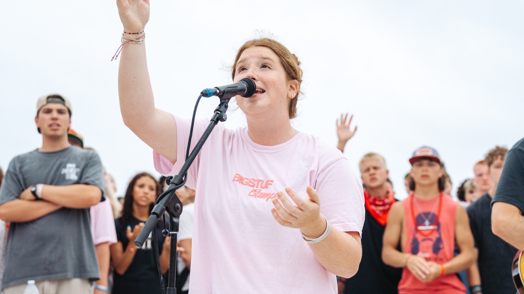 BigStuf 2026 students worshiping together outdoors near the beach