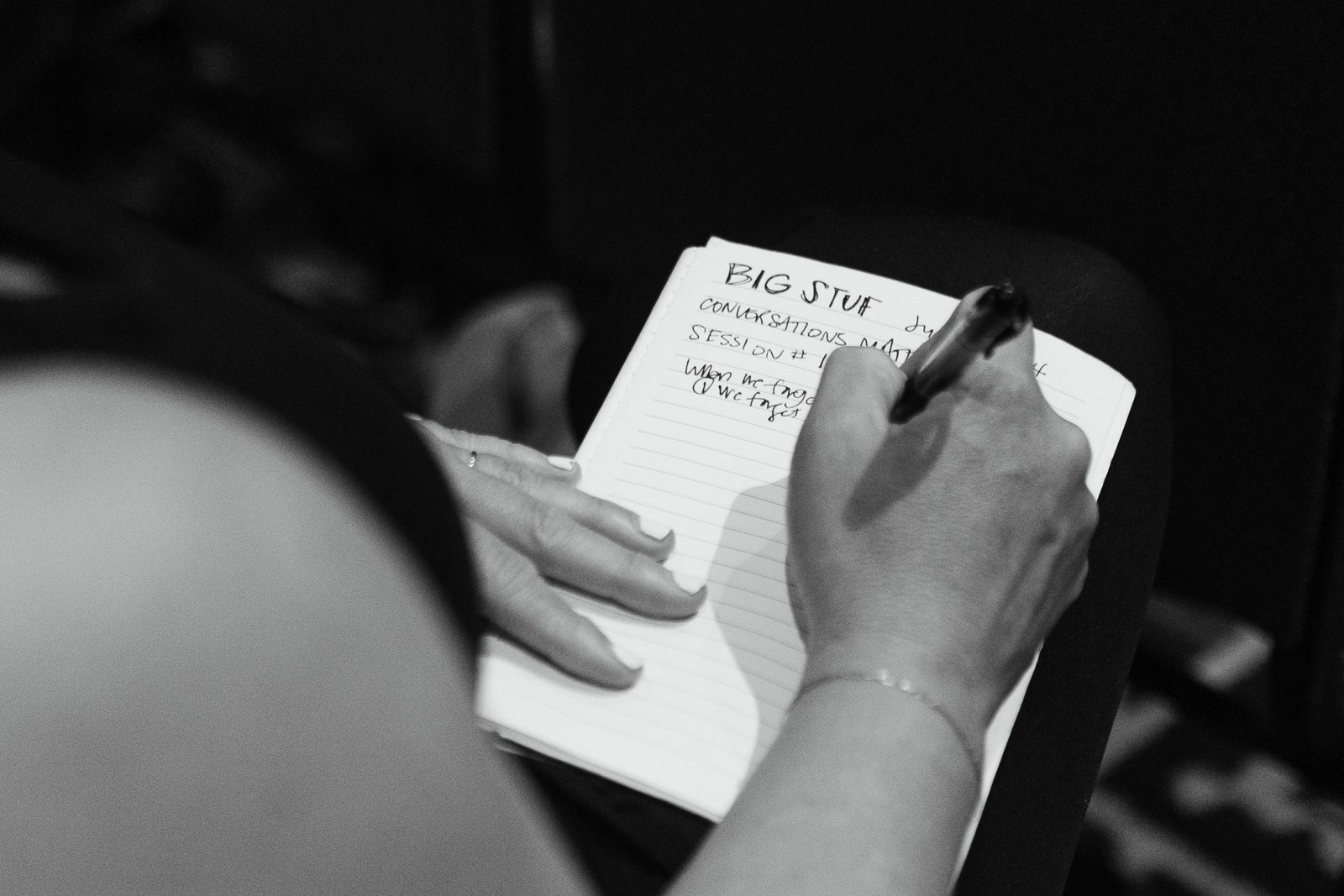 An adult writes in a BigStuf Leader Lab notebook during a 2024 camp session