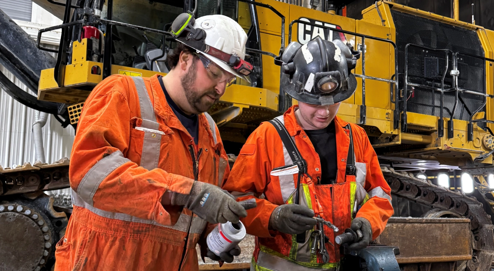 Two mechanics in the process of maintaining a CAT loader