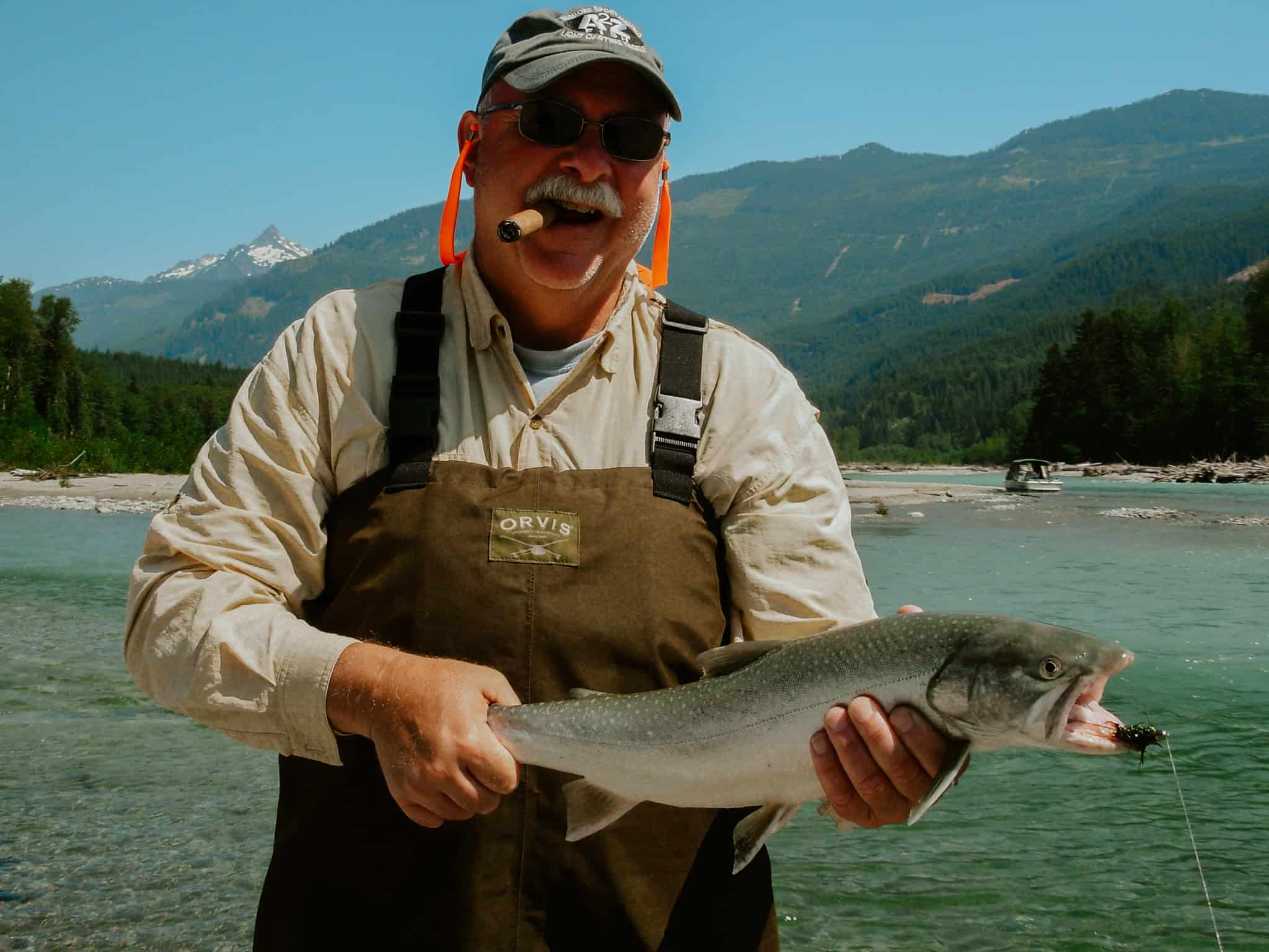 A middle-aged fishing guest with the Fraser River Lodge on a guided fishing trip in the wilderness.
