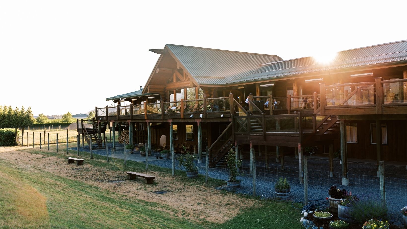 A photo of a wooden lodge with the sun setting behind it