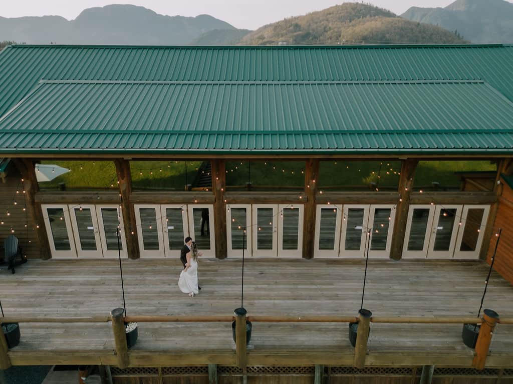 A bride and groom walking on the Fraser River Lodge's deck from a birds eye view