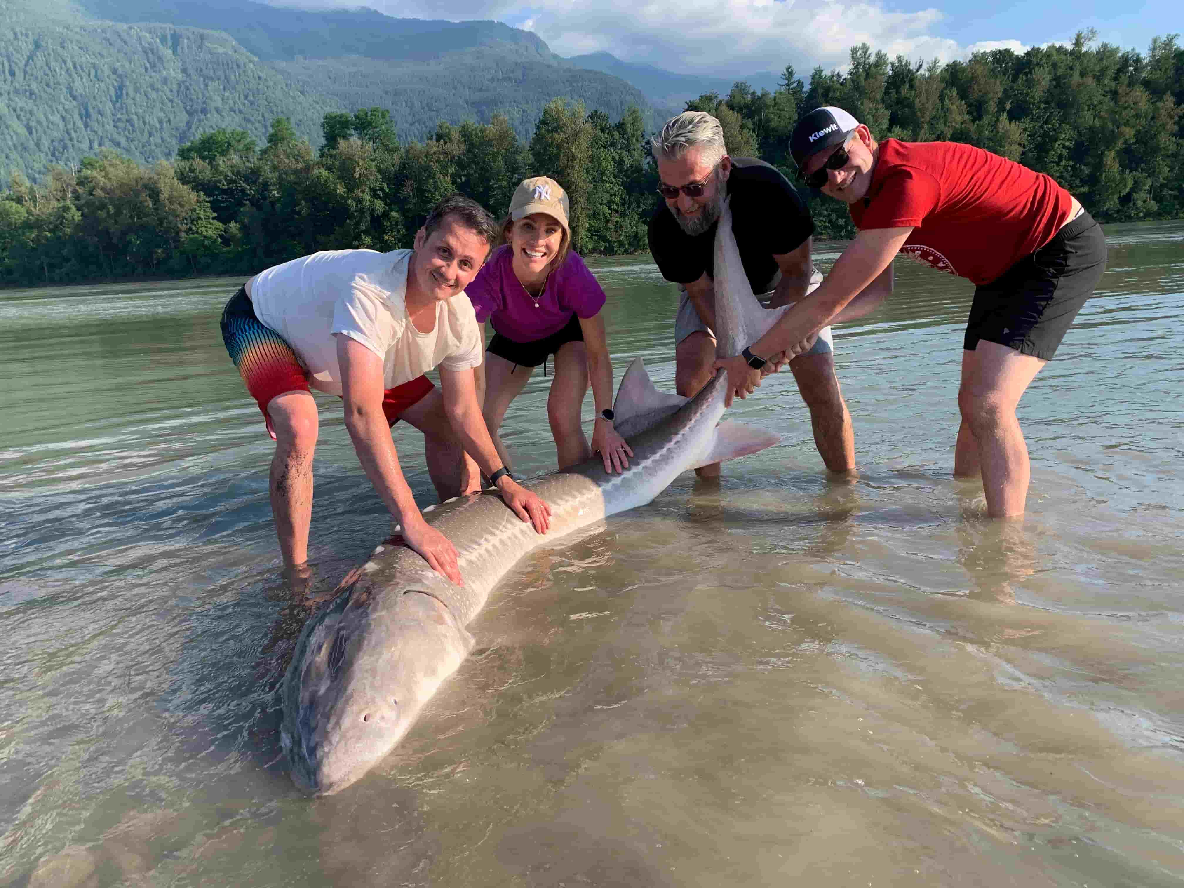 Team celebrating a sturgeon catch during a corporate fishing trip