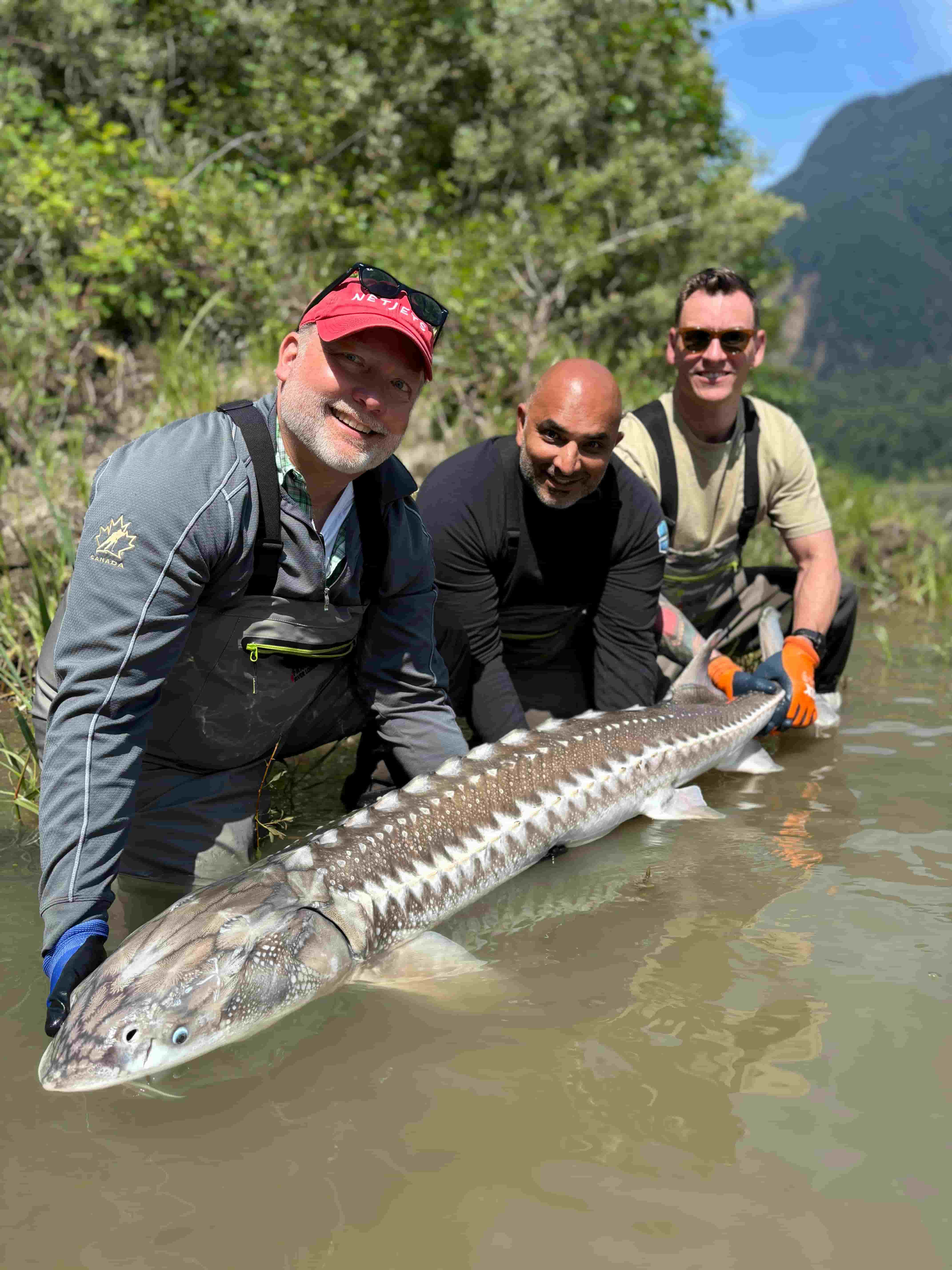 corporate group with their sturgeon catch