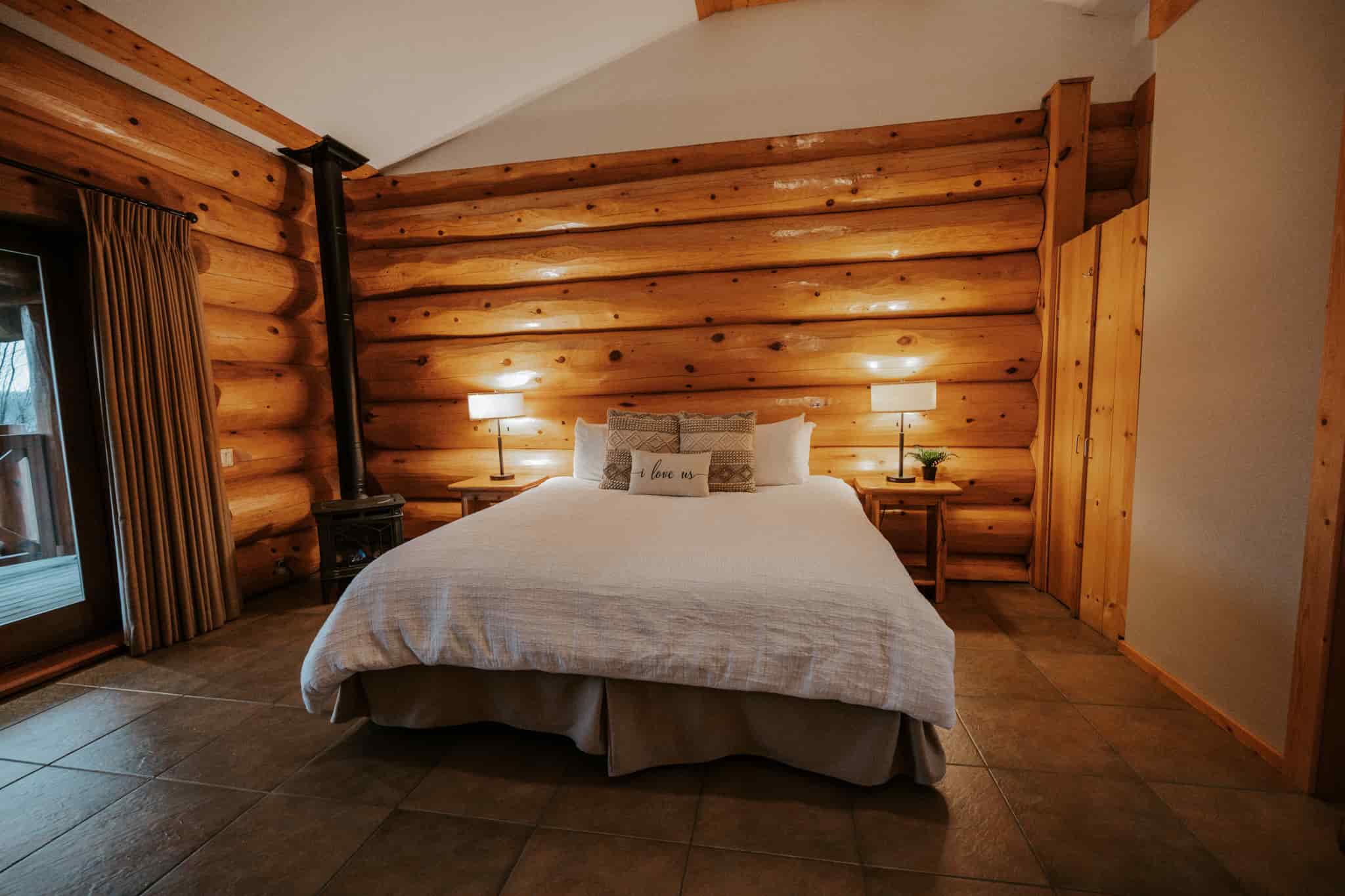 A king sized bed in a log room