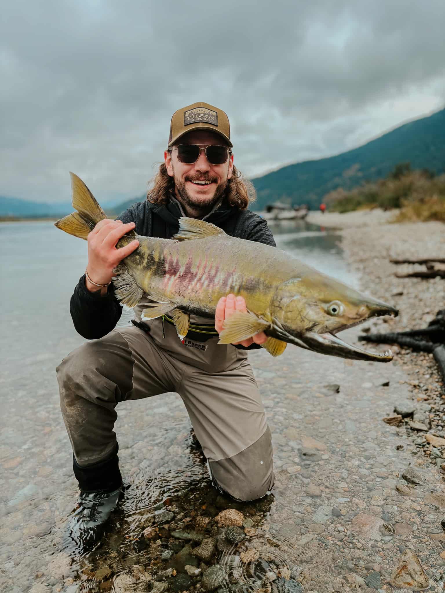 A man holding up his chum salmon catch on the fraser river