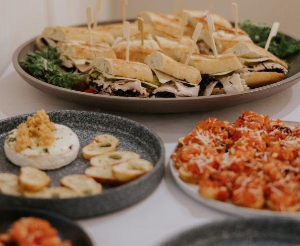 Catered appetizers at Fraser River Lodge, including baguette sandwiches, baked brie with crostini and tomato bruschetta.