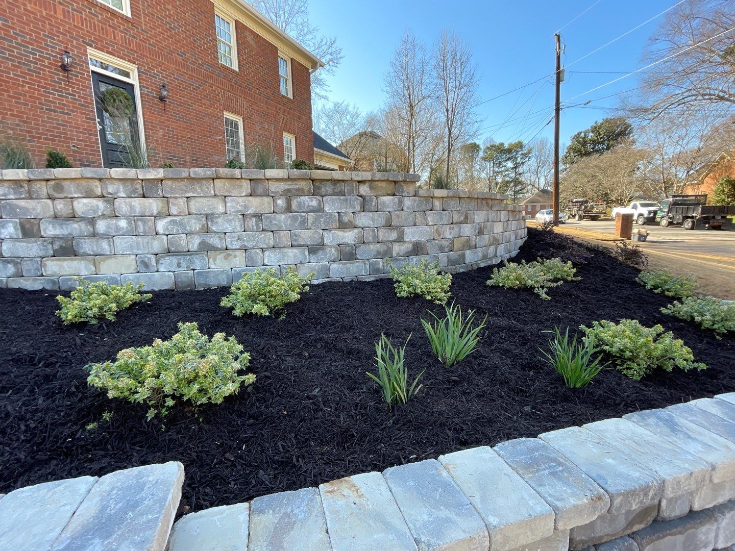 Tiered retaining walls on side of house