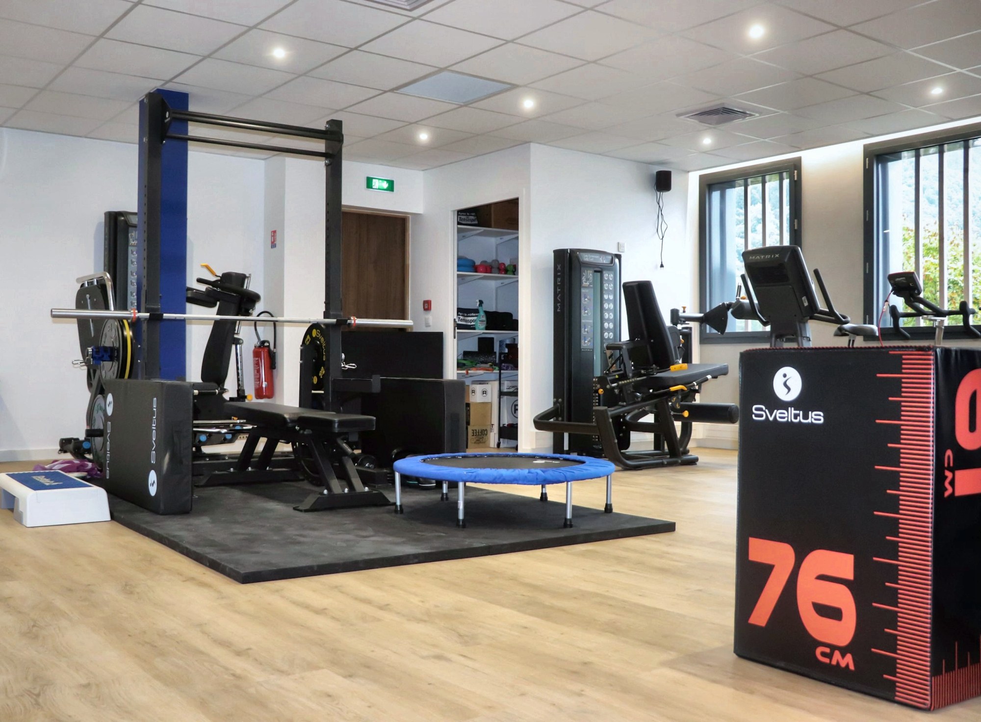 Plateau de renforcement et de réathlétisation du cabinet KVO2 à Annecy : rack, machines guidées, trampoline et box de pliométrie