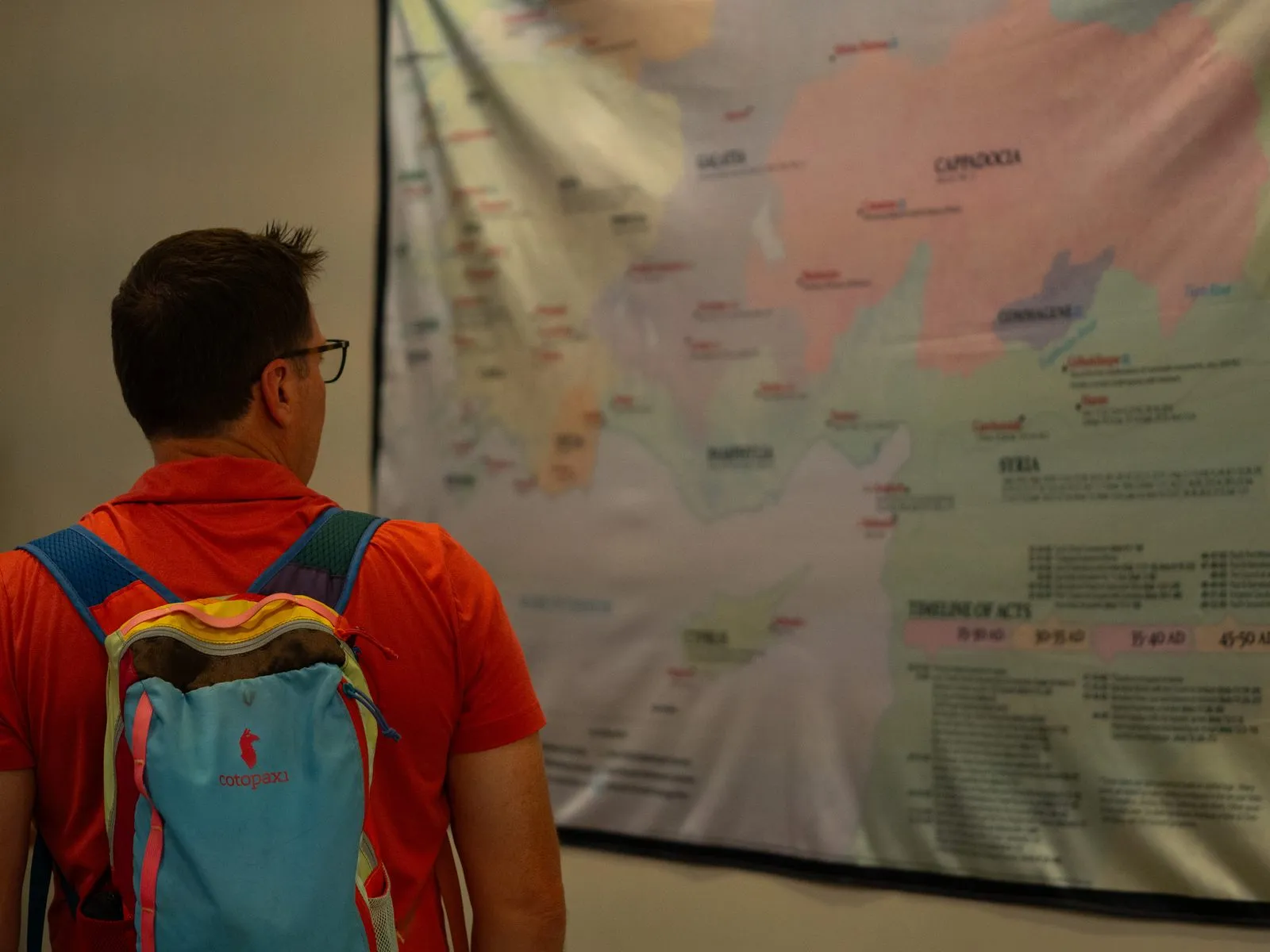 A Nicea Conference attendee studying a large wall map