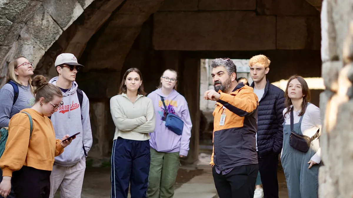Travelers gathered with their guide under a stone vault at the ancient agora of Smyrna