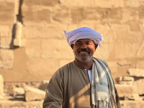 A Karnak temple worker smiling in the morning light.