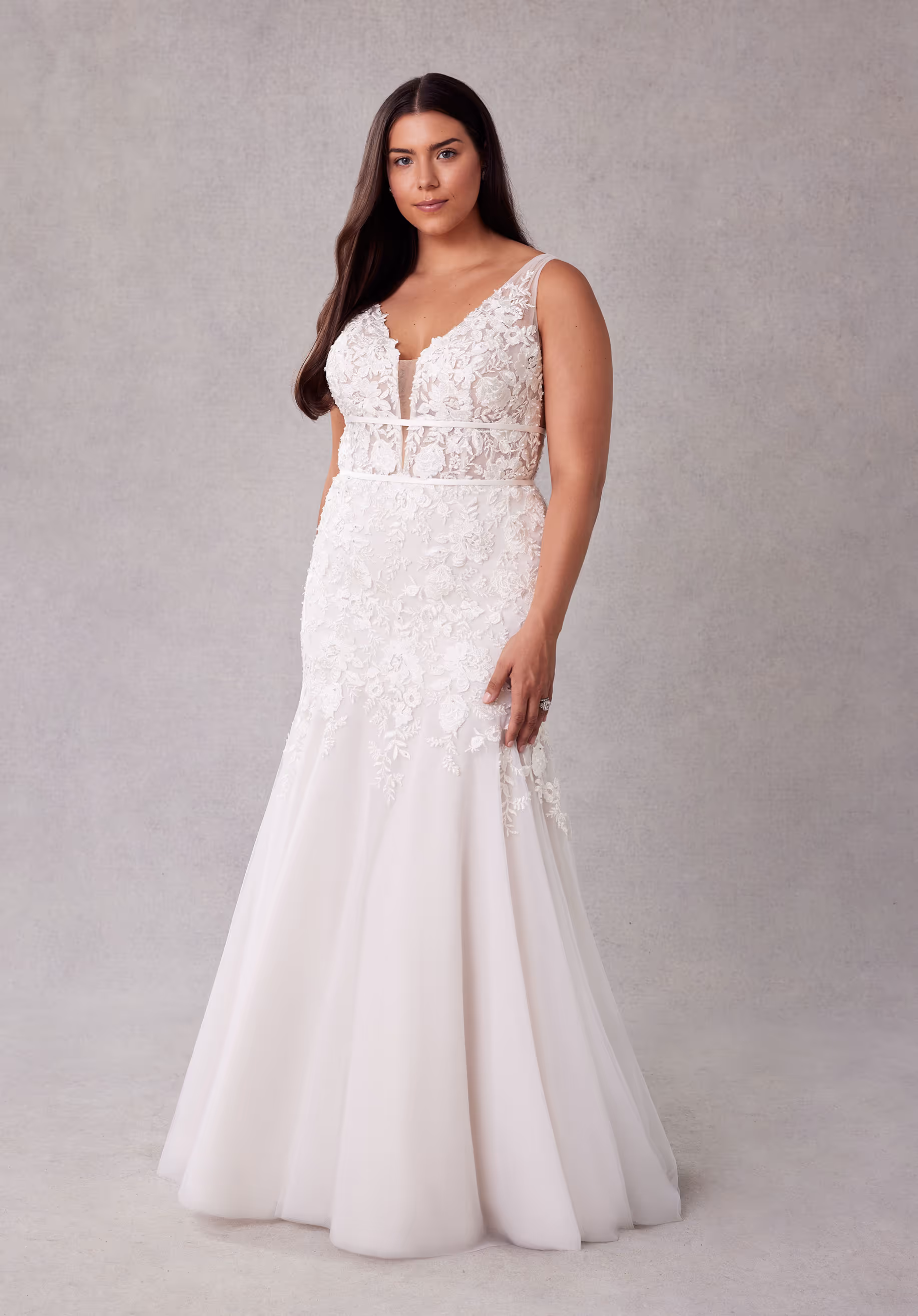 Botanical mermaid wedding dress has a sheer plunging bodice and double banded waist with crystal beaded embroidered lace appliqués and an open back.