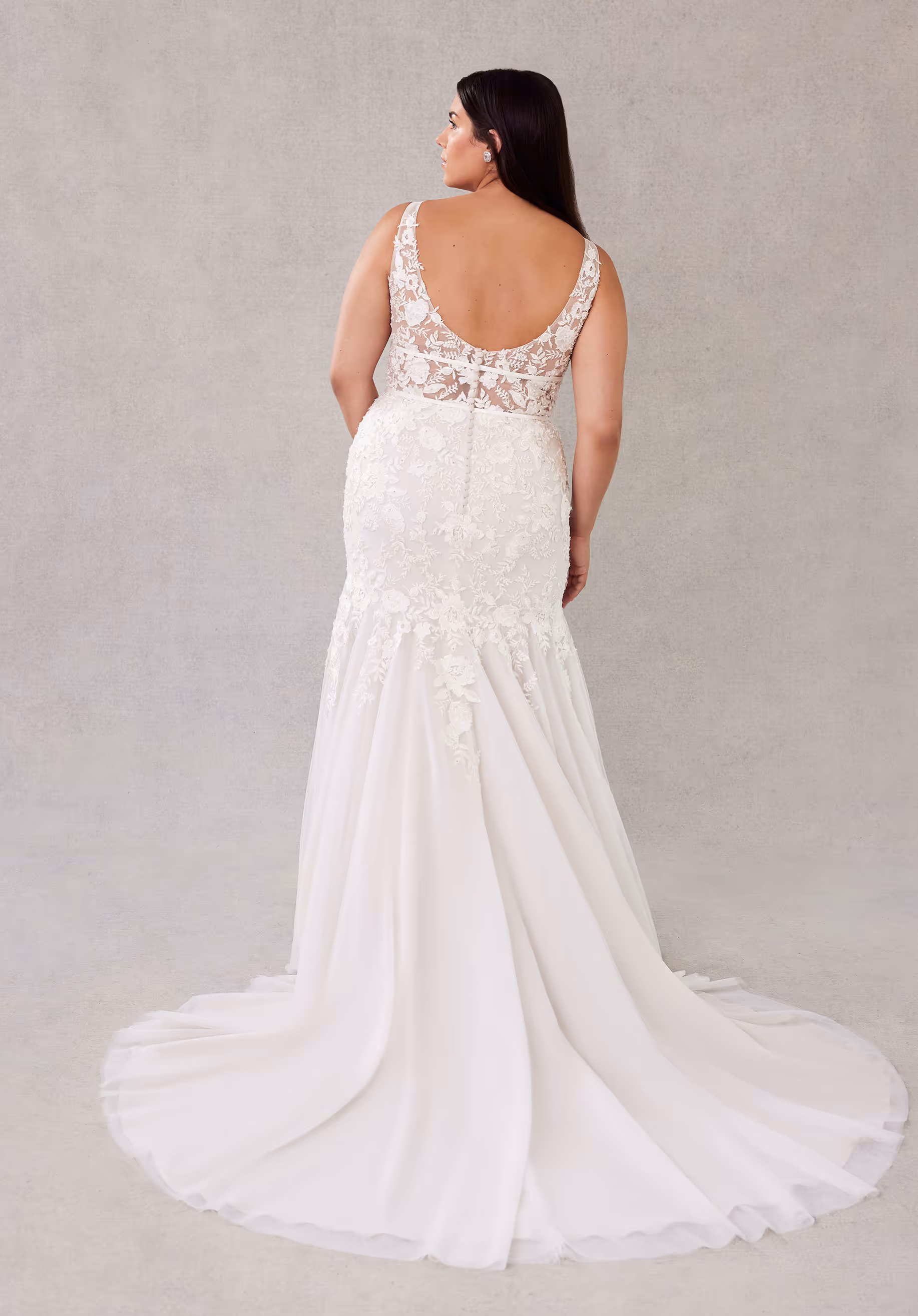 Botanical mermaid wedding dress has a sheer plunging bodice and double banded waist with crystal beaded embroidered lace appliqués and an open back.