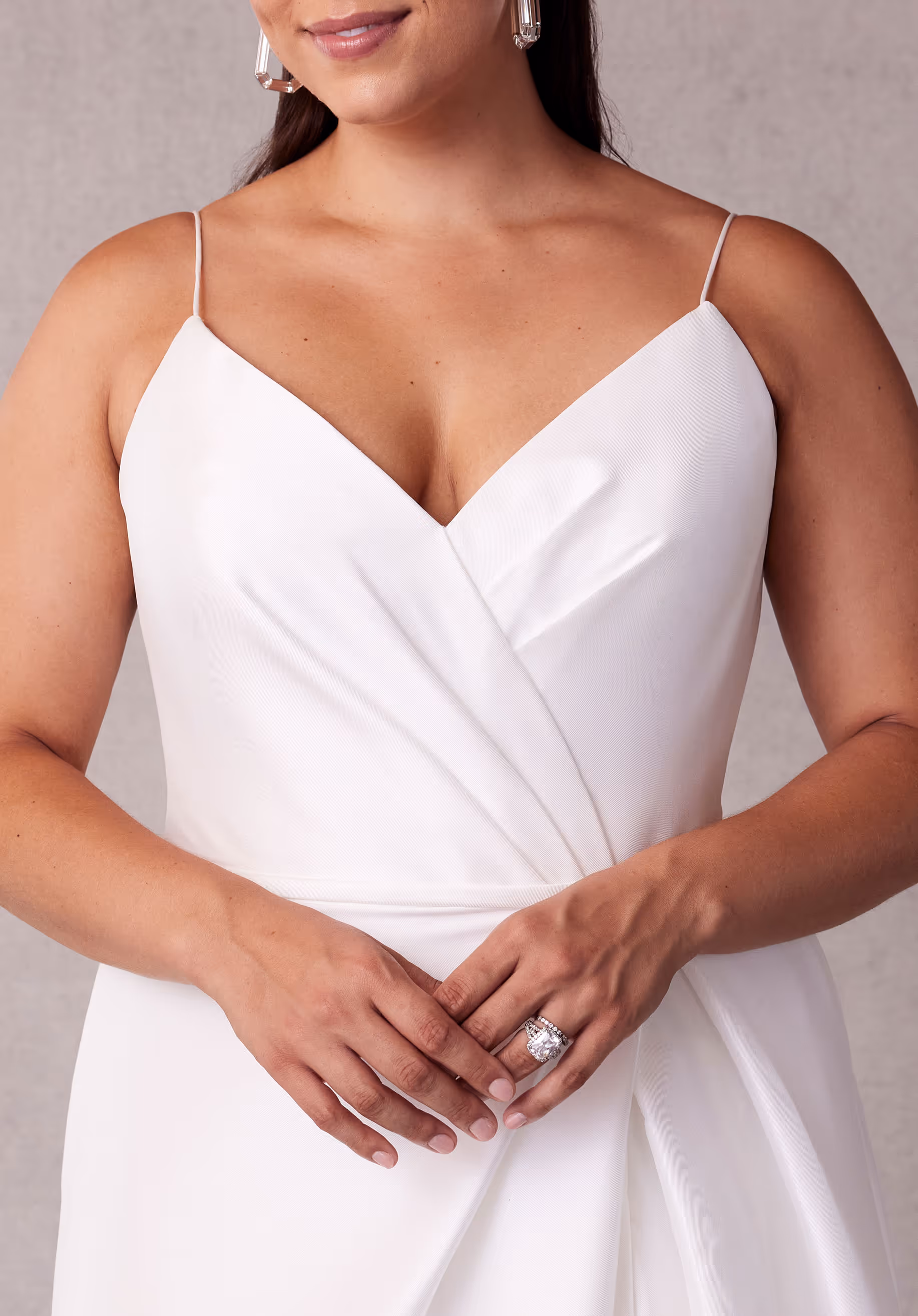 Elegant A-line wedding dress has a draped, surplice bodice with delicate straps, a waistband, and draped skirt slit in stretch Larissa satin.
